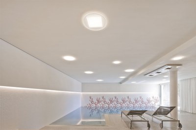 In the swimming pool, the otherwise strictly regular arrangement of the luminaires gives way to Module R 144 luminaires irregularly spread about the ceiling. The all-round cove lighting creates a special kind of light – a LED light strip housed in a ledge around the wall illuminates a glass mosaic both above and below the surface of the water