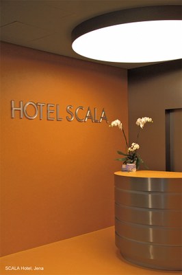 The pure design of the SCALA Turm Hotel reception desk is underlined by a clear and friendly illumination