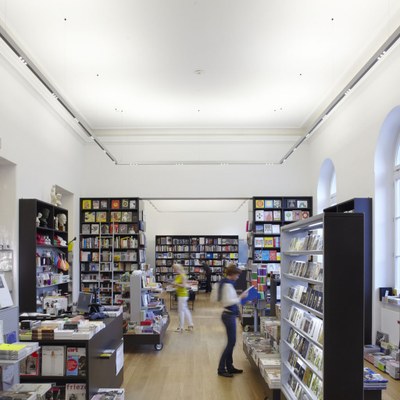 Large glass doors and a consistent lighting concept using the Supersystem link the adjoining book store with the museum foyer.