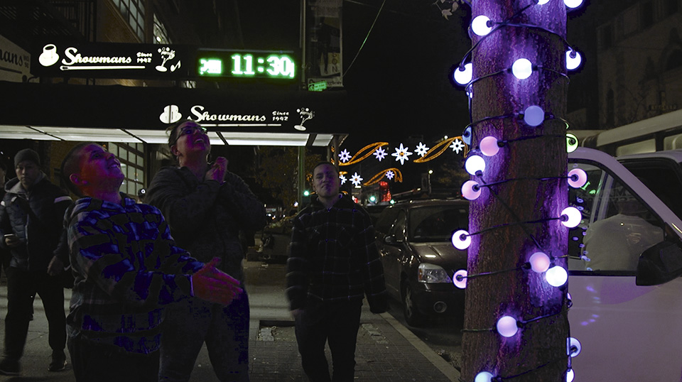 Figure 4: Fascinated youths tinkering with an interactive light in front of the Showmans Jazz Club in New York City