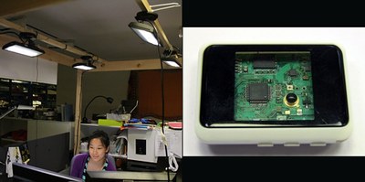 Visiting student Nan Zhao works in the test setup at the Media Lab under four LED fixtures controlled by the prototype adaptive system (left). The currently used device that incorporates sensors and controls is not much bigger than a credit card (right). Photo courtesy of Matt Aldrich