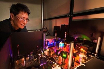 Sandia researcher Jeff Tsao examines the set-up used to test diode lasers as an alternative to LED lighting. Skeptics felt laser light would be too harsh to be acceptable. Research by Tsao and colleagues suggests the skeptics were wrong. (Photo by Randy Montoya)