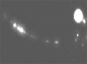 Optical image of the same nanowire in action. Most of the light emitted from the device is in the ultraviolet portion of the spectrum, but enough visible light is generated to see it glowing.