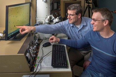 Sandia National Laboratories researchers Dale Huber, left, and Todd Monson have come up with an inexpensive way to synthesize titanium-dioxide nanoparticles, which could be used in everything from solar cells to light-emitting diodes. (Photo by Randy Montoya)
